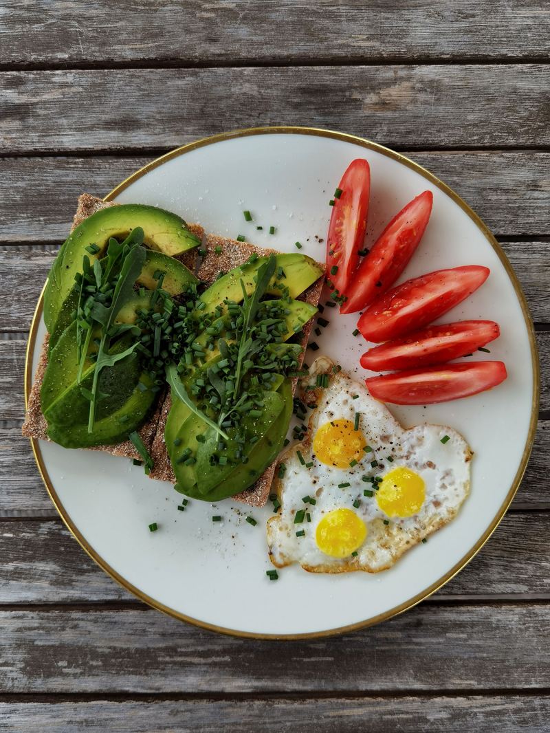 Avocado-Brot mit Spiegeleiern und Tomaten