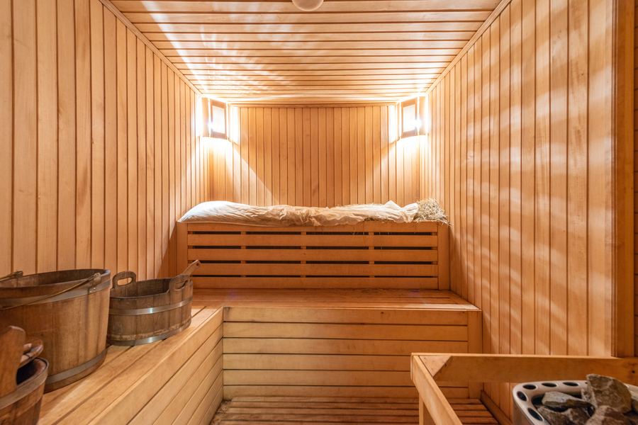 Sauna aus hellem Fichtenholz mit Liegen